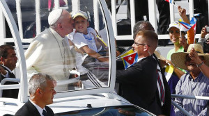 Francisco kisses a Cuban boy.