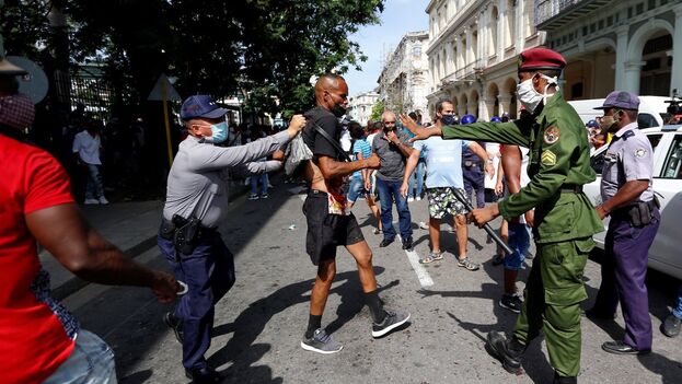 Several police officers arrest a man while he was demonstrating in Havana, on July 11